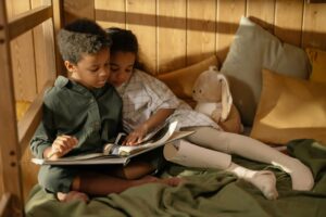 two children reading a book - readers